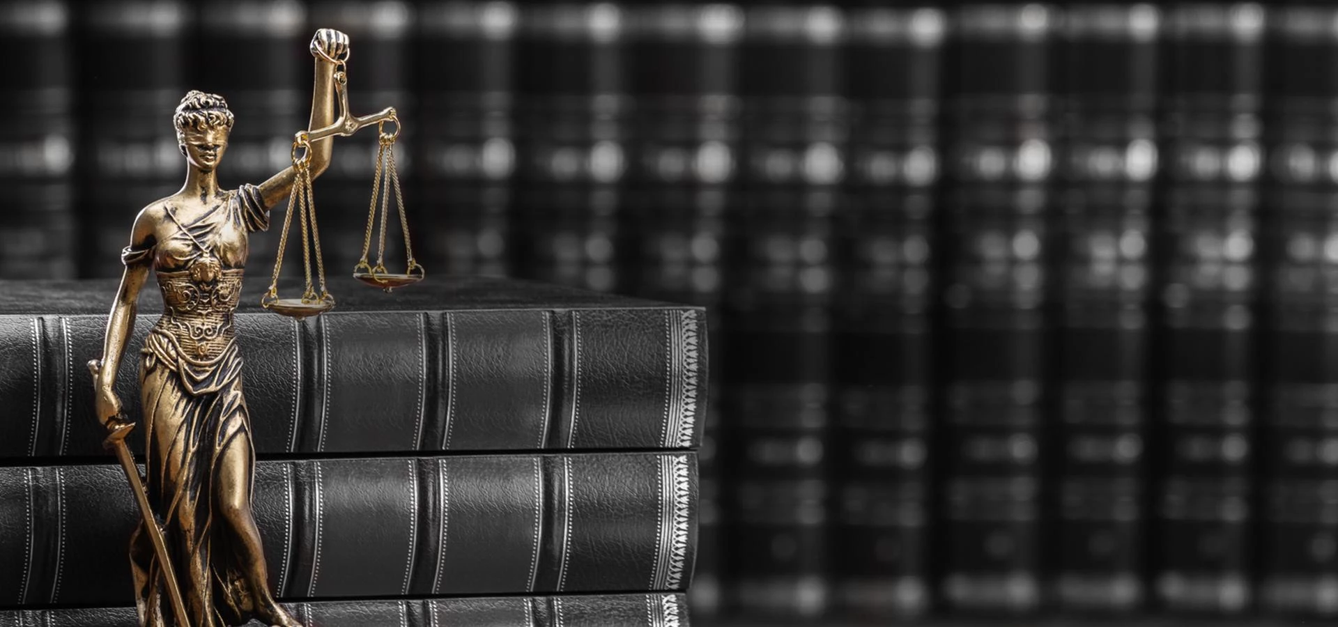 Figurka temida i księgi w tle